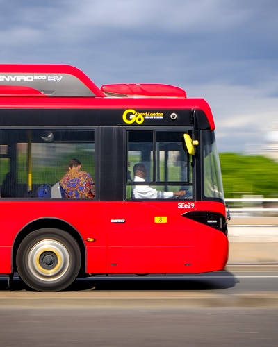 a red bus driving down the road